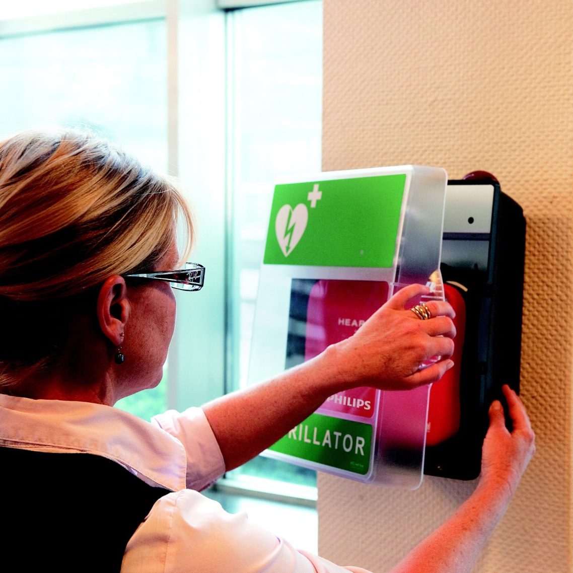 Lady opening aed cabinet